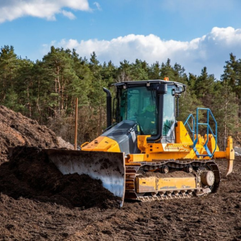 Bulldozer rental machine pushing soil at construction site